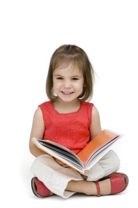 Preschool girl w book sitting crisscross, isolated dreamstime_m_3469234